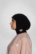 Muslim woman in black sport hijab wearing beige modest active top — TURAYA MOVE Canada
