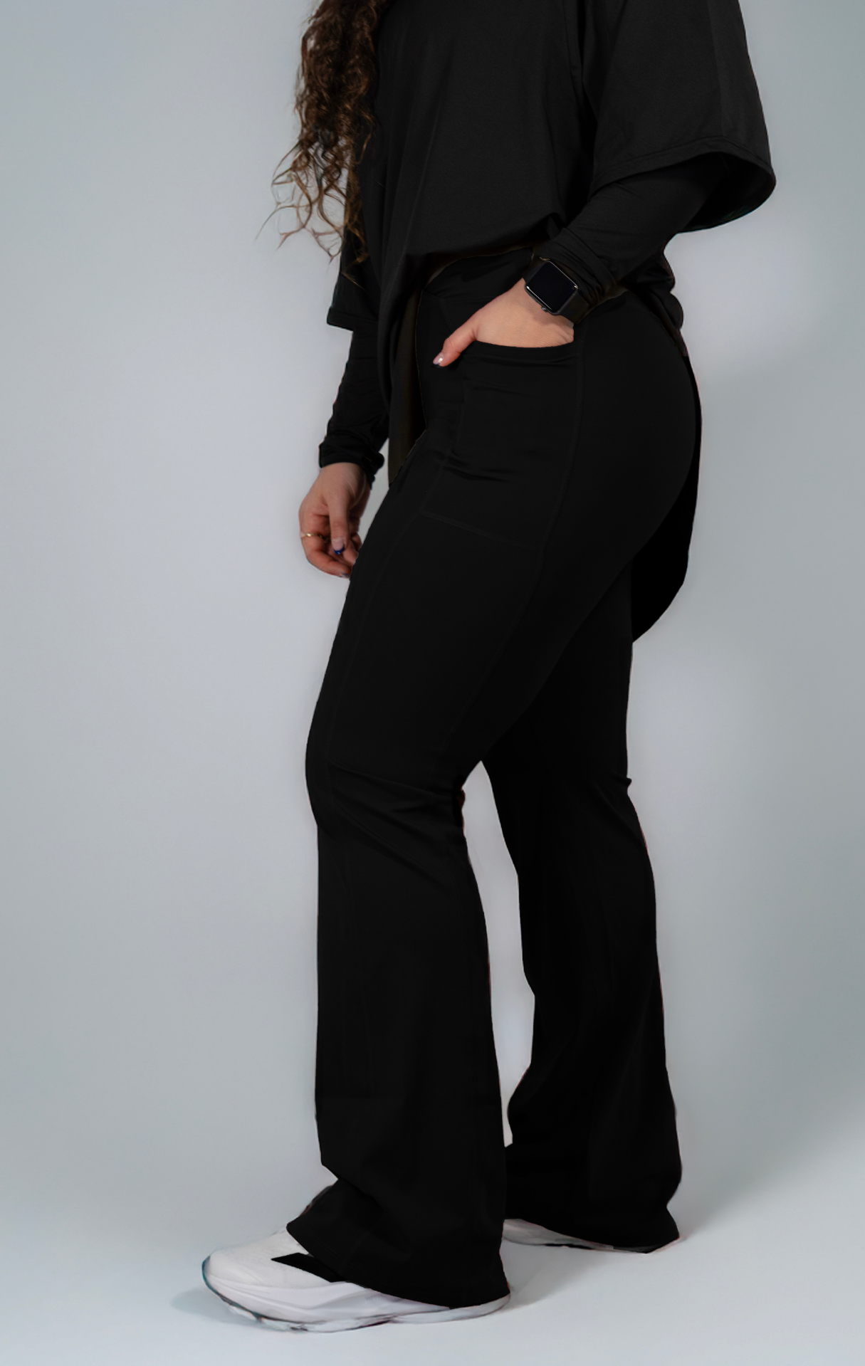 Woman wearing modest black oversized active top with flare pants — TURAYA MOVE