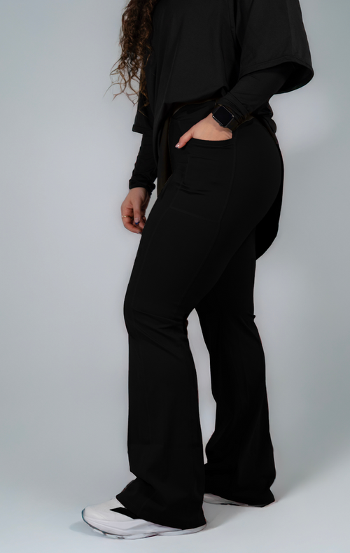 Woman wearing modest black oversized active top with flare pants — TURAYA MOVE