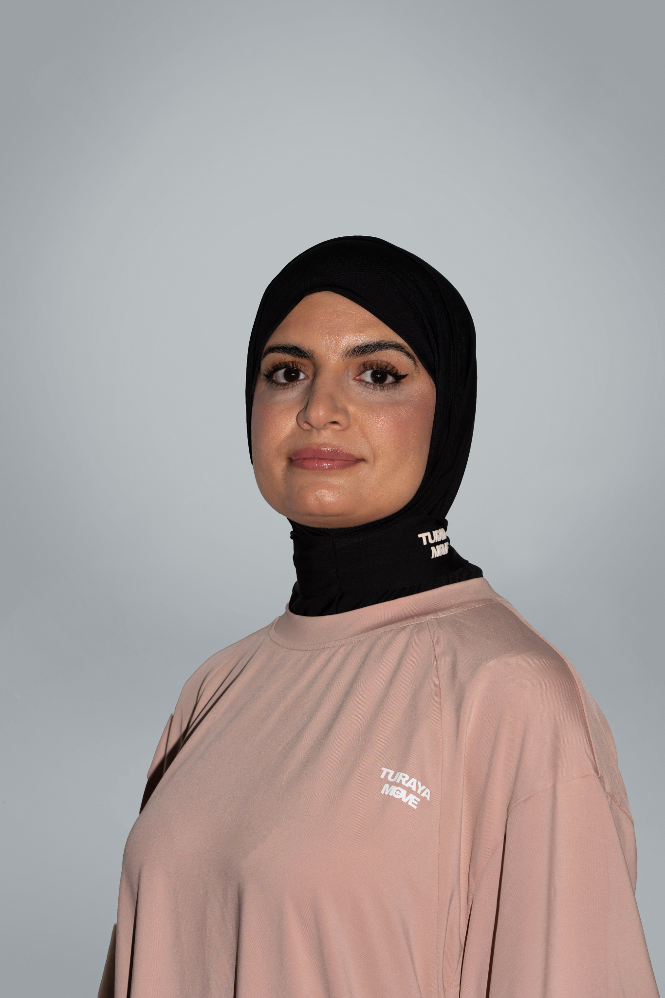 Muslim woman in black sport hijab wearing beige modest active top — TURAYA MOVE Canada